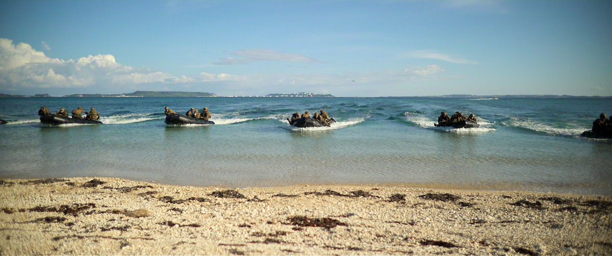 Marines on boats approach the shore