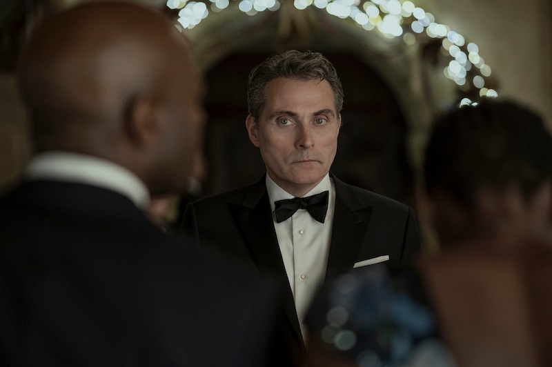 A gentleman in a tuxedo looks to the left with trepidation.