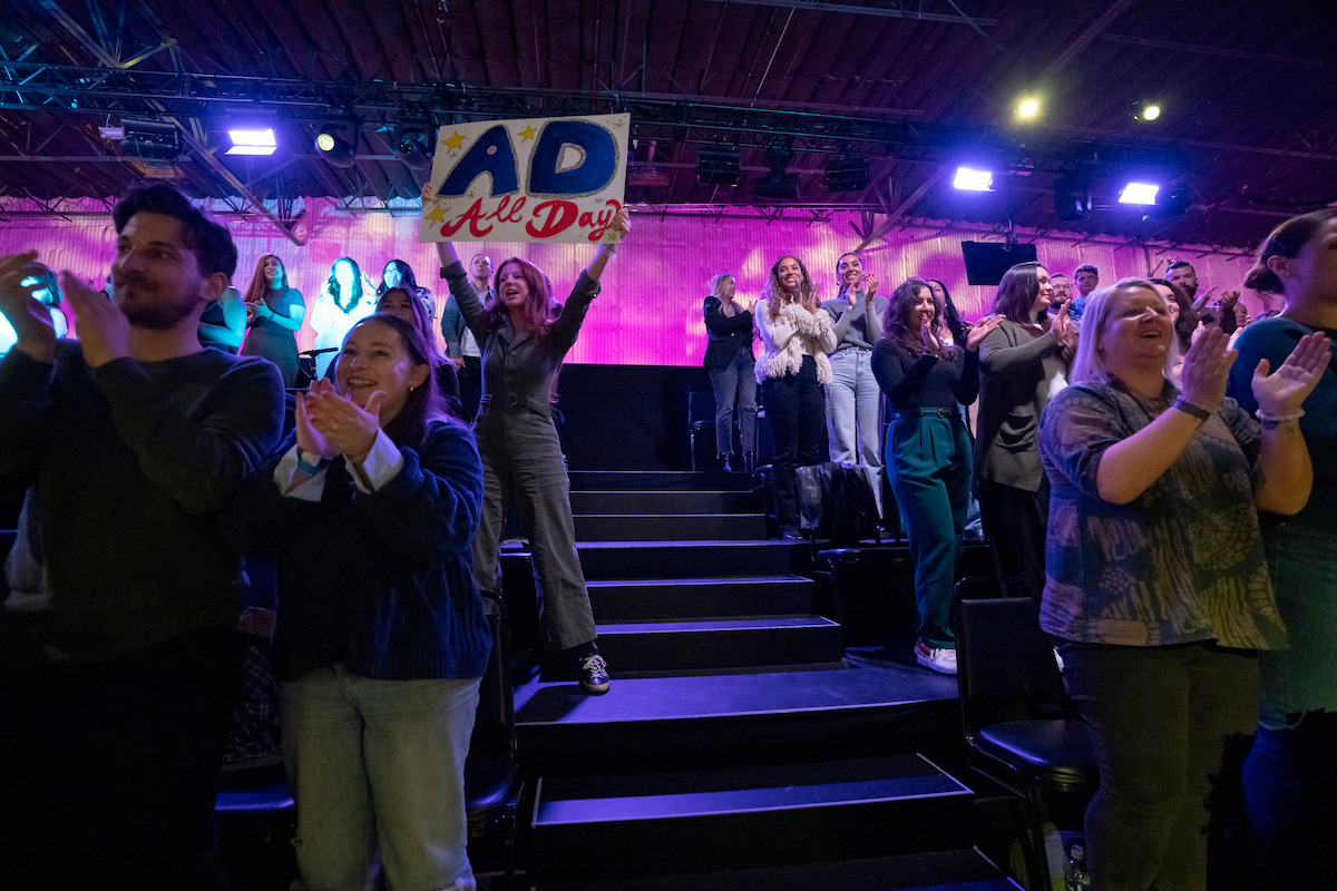 Crowd member holding up a sign in the season 6 reunion of Love is Blind.
