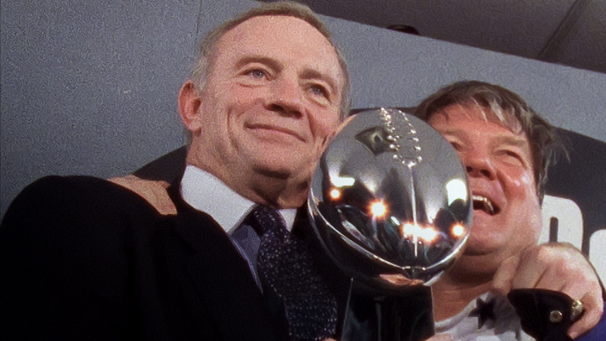 Jerry Jones and Jerry Jones holding the Vince Lombardi Trophy.