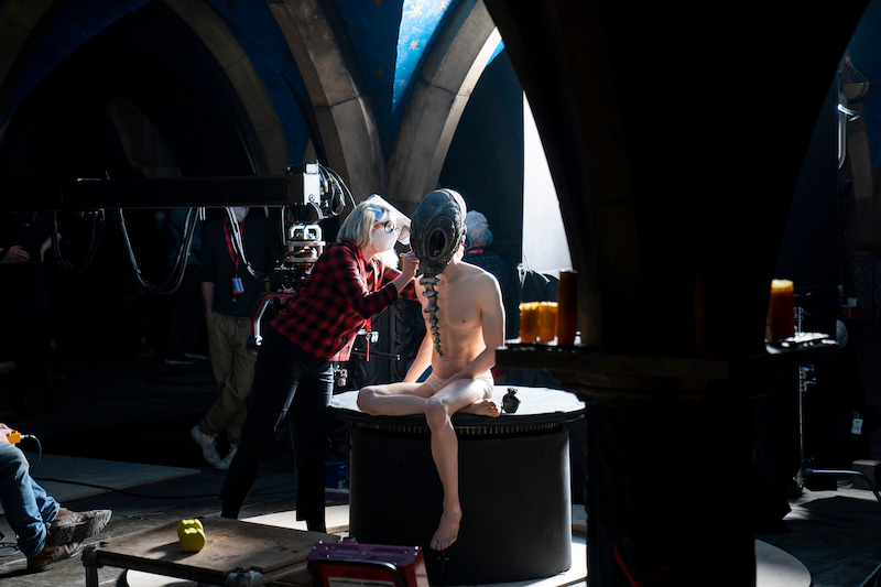 A nearly naked Morpheus (Tom Sturridge) gets some final touches put on his mask.