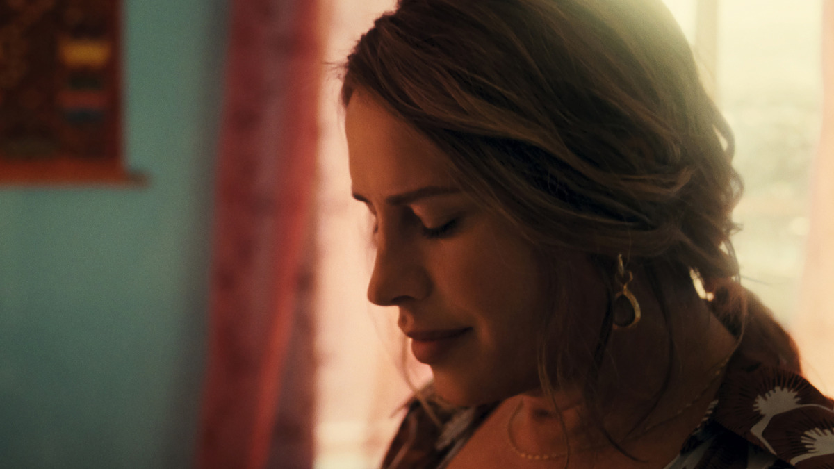 Emilia Pérez (Karla Sofía Gascón) smiles slightly and looks down. So demure!