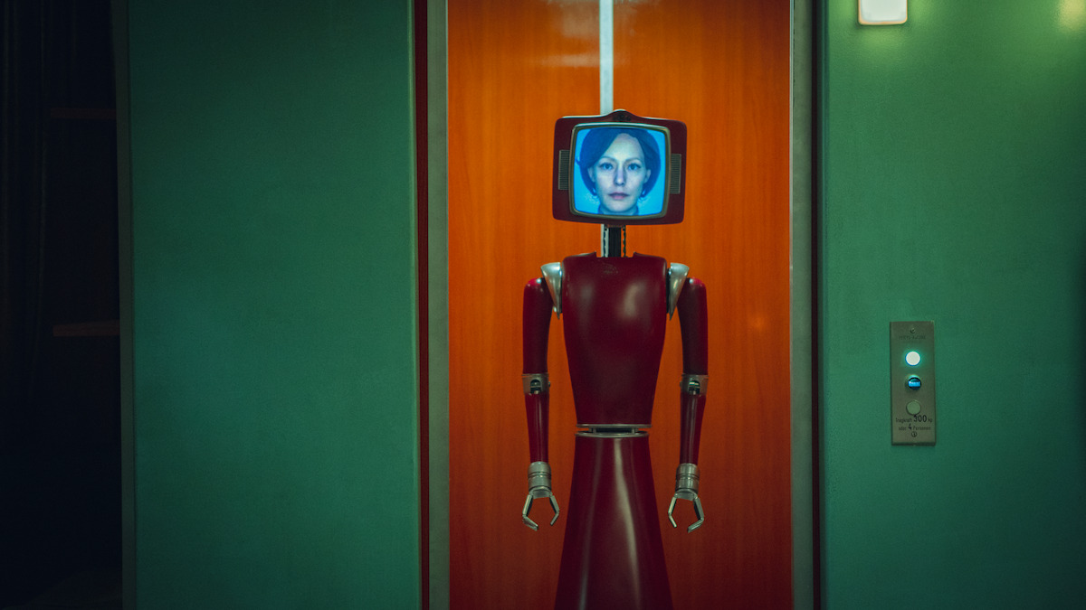 Lavinia Wilson's face appears on the television screen, which serves as the head of a new-body robot in the series