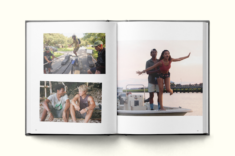 Photo book open to pages showing three outdoor scenes: friends skateboarding in a park, two people having a conversation outside, and a joyful pair on a boat at sunset, with water and a bridge in the background.