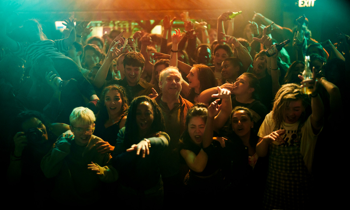 Paul Giamatti stands in a crowd at a concert in Season 7 of ‘Black Mirror’