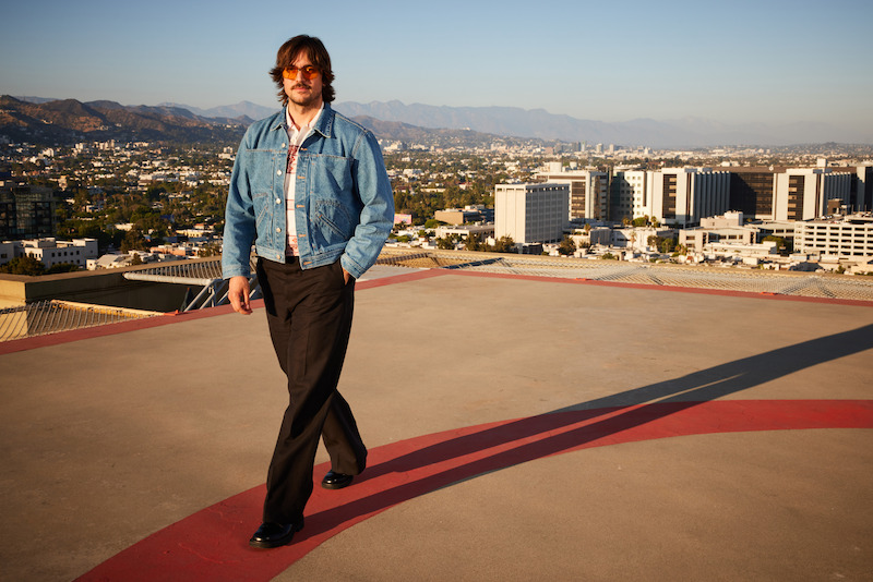 Lucas Bravo poses on a rooftop in Los Angeles. 