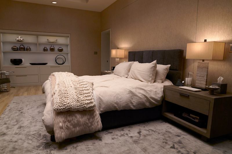 Modern, sparse bedroom with a bed in the middle. 