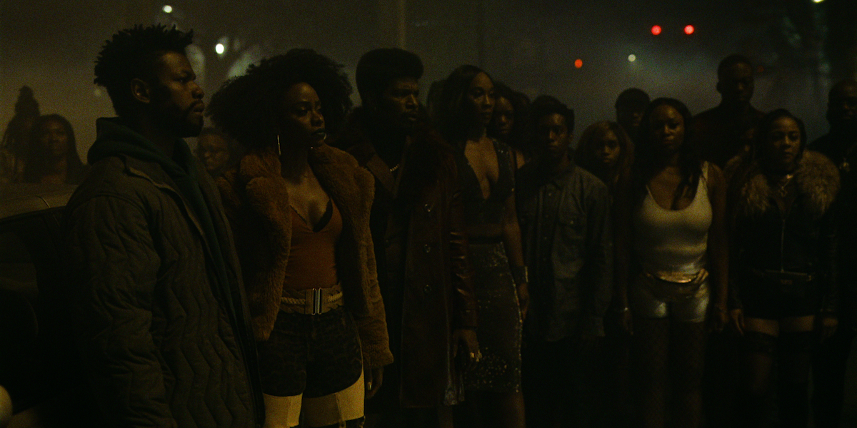 Jamie Foxx as Slick Charles, Teyonah Parris as Yo-Yo, and John Boyega as Fontaine surrounded by a crowd. 
