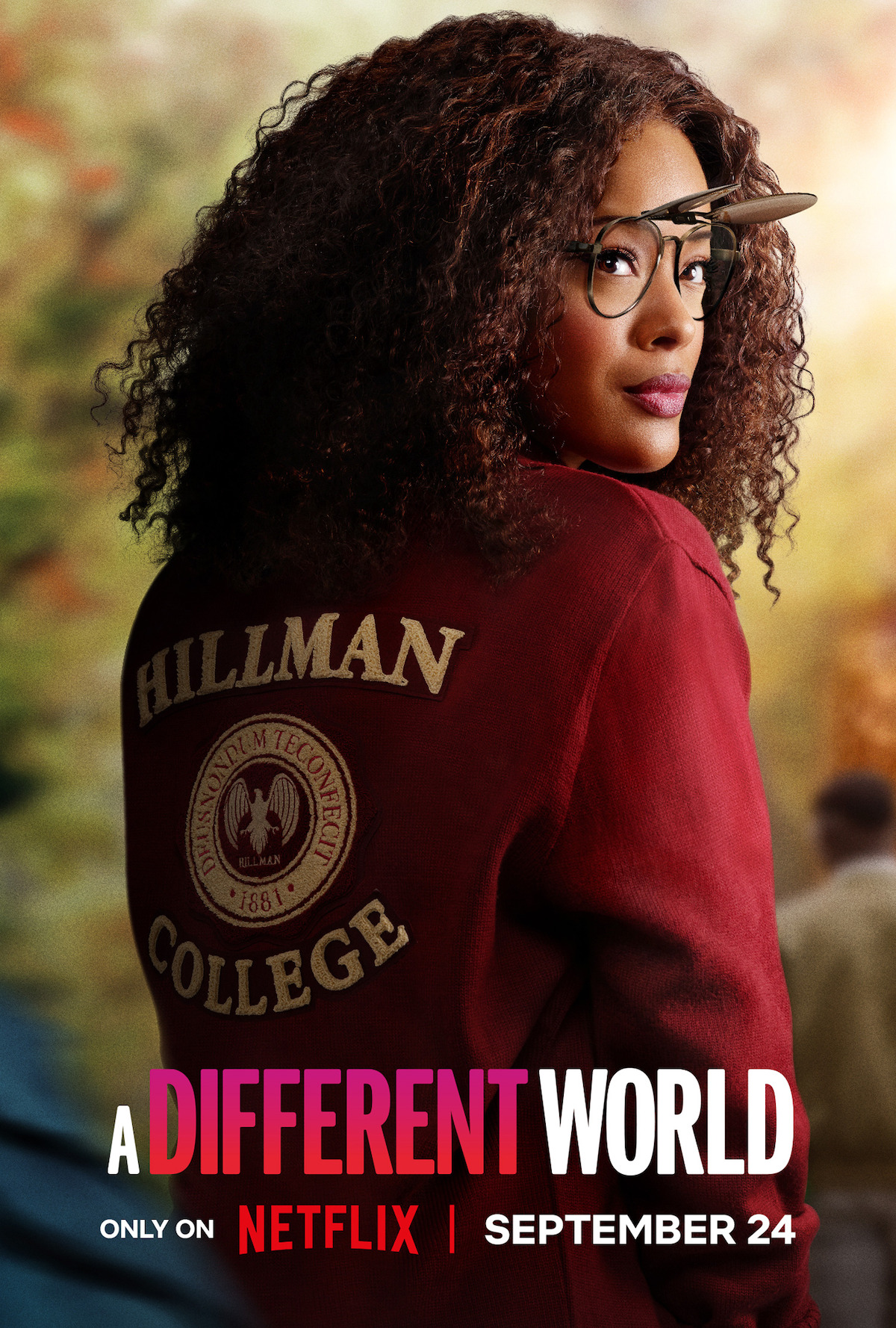 A woman with curly hair and glasses wears a Hillman College jacket outdoors. The background is blurred with trees and people. Text reads "A Different World," Netflix logo, and September 24 release date.