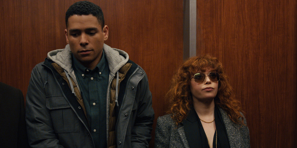 Natasha Lyonne as Nadia in ‘Russian Doll.’ She’s wearing sunglasses in an elevator standing next to Charlie Barnett, who’s wearing a jacket and hoodie.