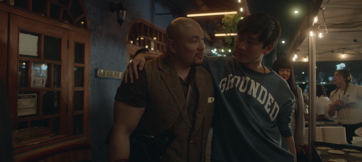 Jon Xue Zhang as Blood Boots and Sam Song Li as Bruce Sun hang out together at a taco stand in season 1 of ‘The Brother Sun’