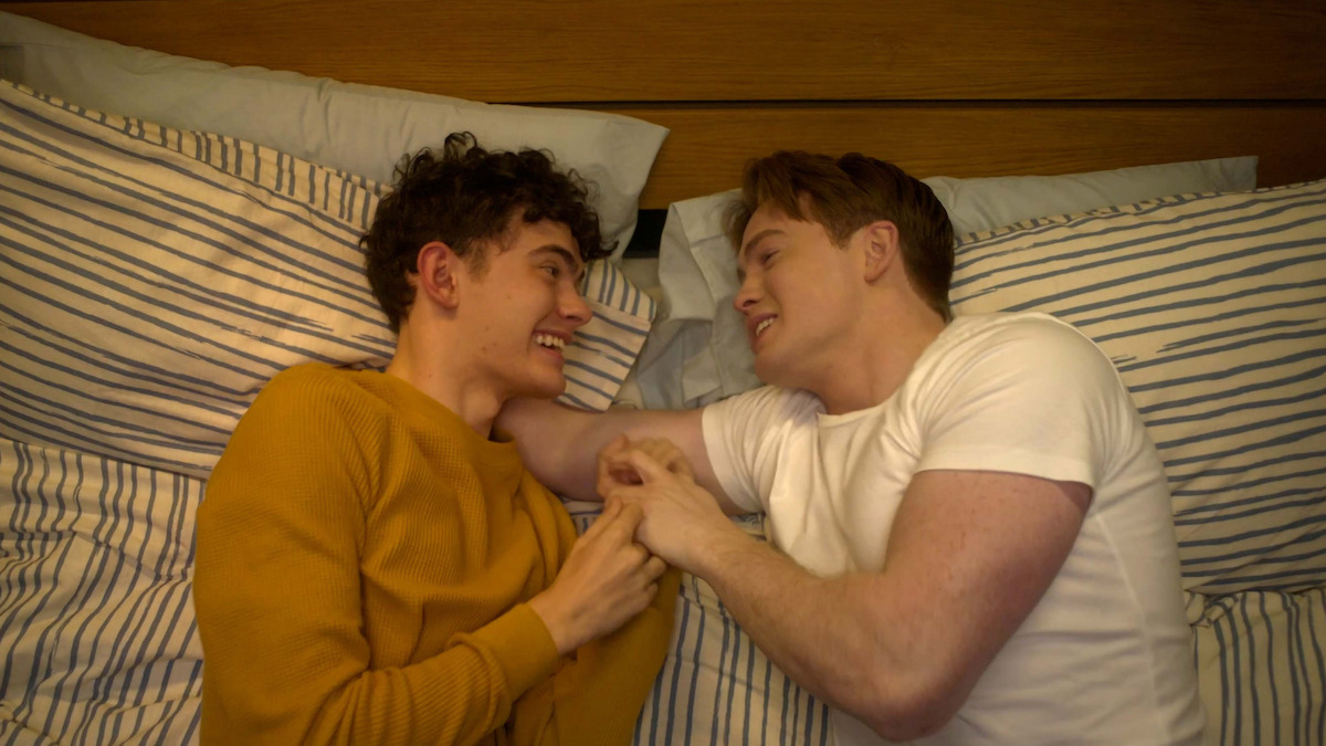 Joe Locke as Charle and Kit Connor as Nick cuddle together in bed in Season 3 of 'Heartstopper'