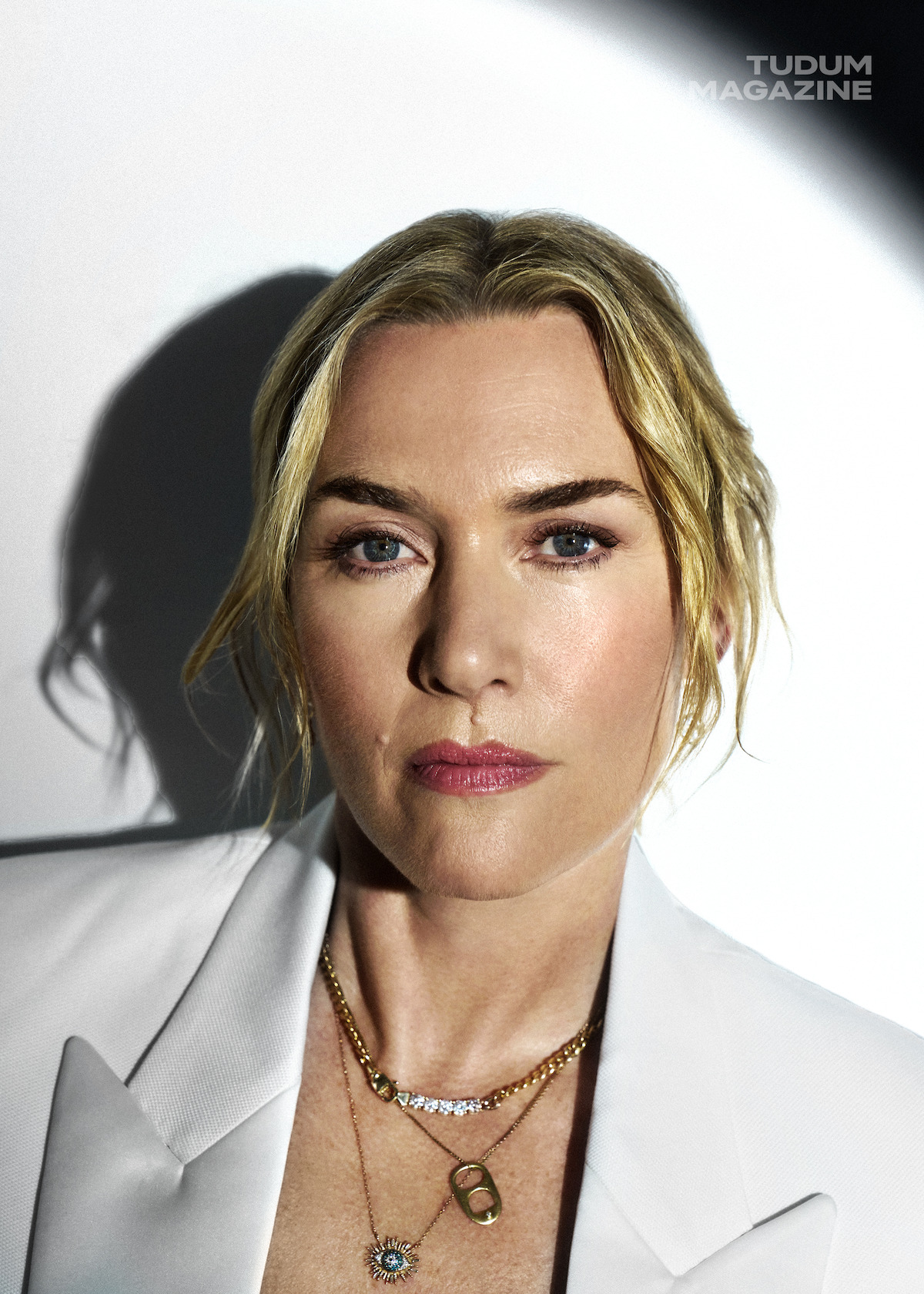 Kate Winslet stares into the camera on a white backdrop.