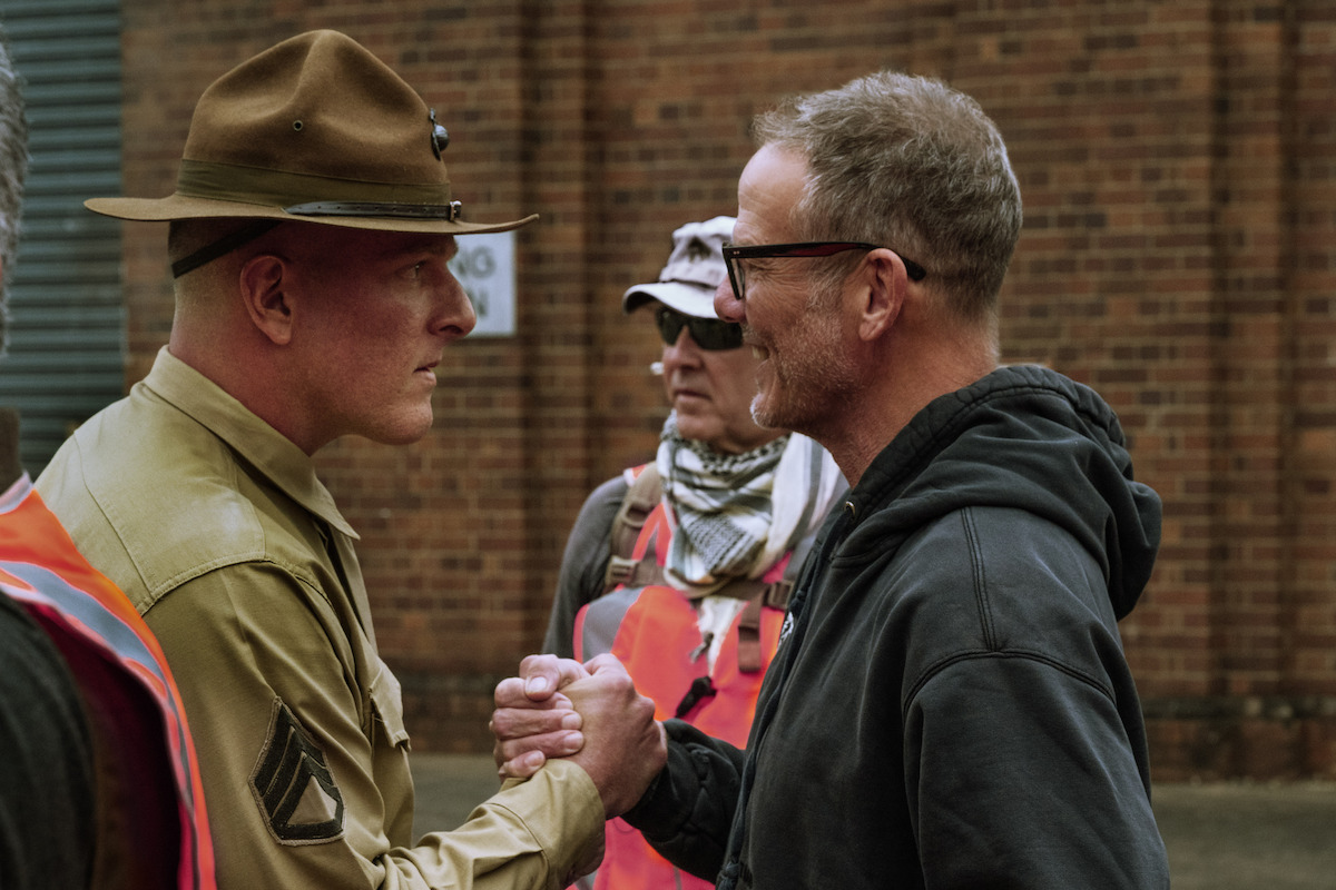 Behind-the-scenes photo of Pat McAfee as Drill Sergeant and Director Peter Berg on the set of ‘The Mosquito Bowl.’