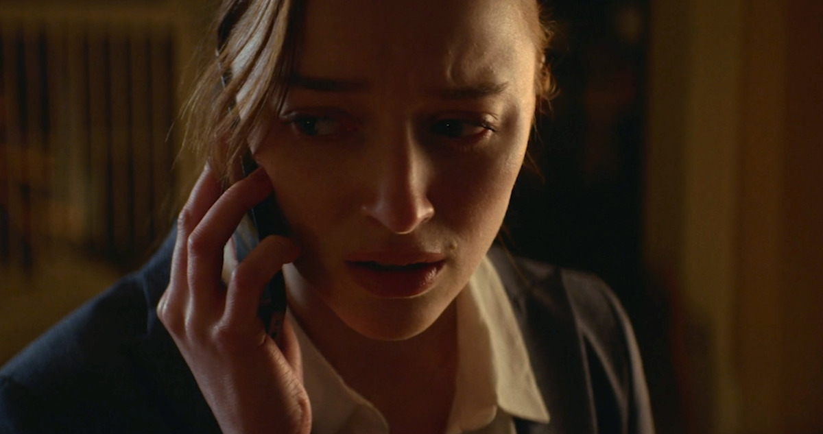 Phoebe Dynevor holds a phone up to her ear in 'Fair Play.'