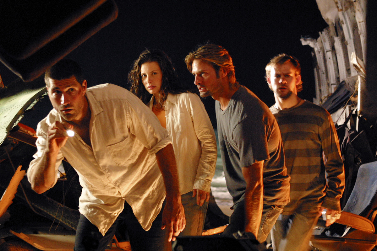 Matthew Fox shining a flashlight as Evangeline Lilly, Josh Holloway, and Dominic Monaghan look on.