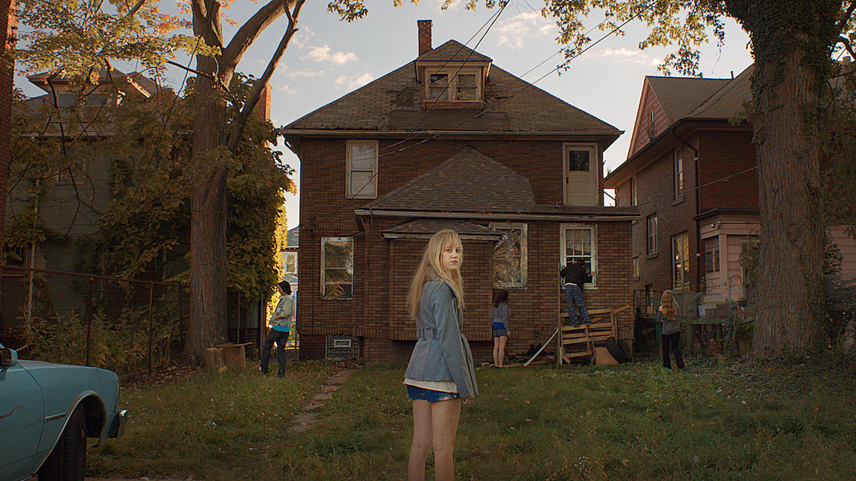 Maika Monroe as Jay Height stands in front of an hold house in ‘It Follows.’