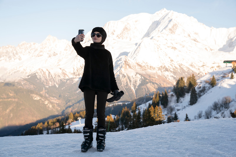 Lily Collins as Emily takes a selfie in the snow  in Season 4 of 'Emily in Paris'