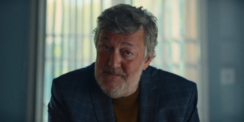 Stephen Fry as Dr. Nell sits at his desk in Season 1 of 'Everything Now.'