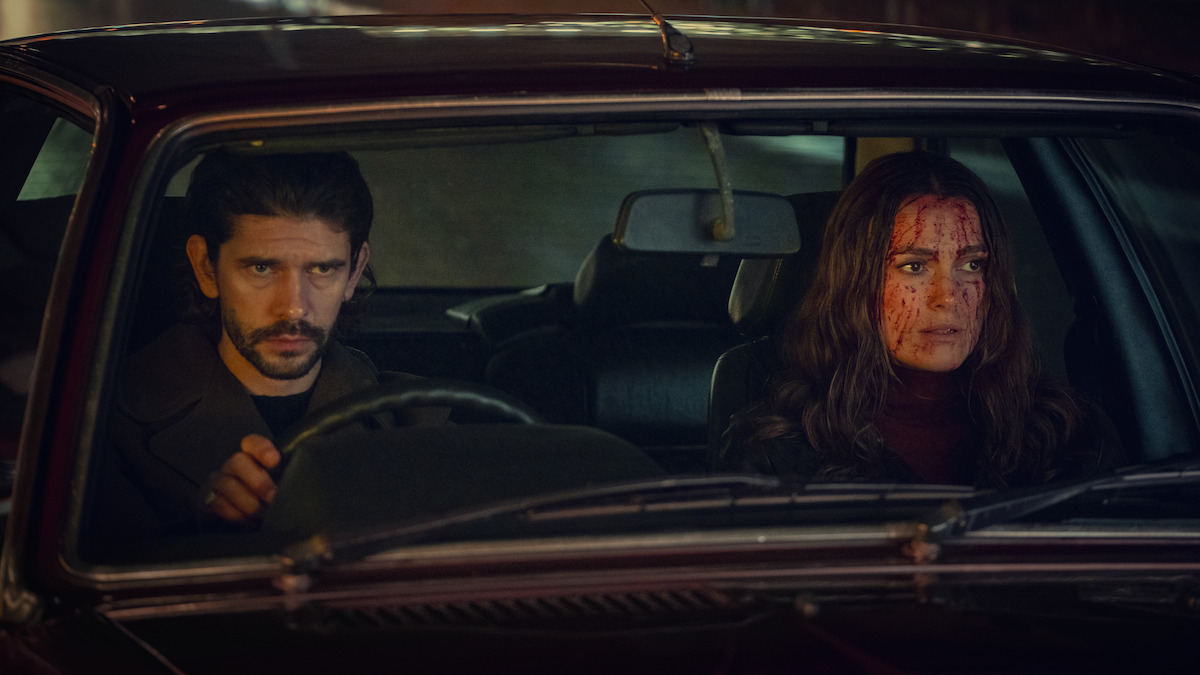 Ben Whishaw drives a car and Keira Knightley sits next to him with her face covered in blood in Season 1 of 'Black Doves'
