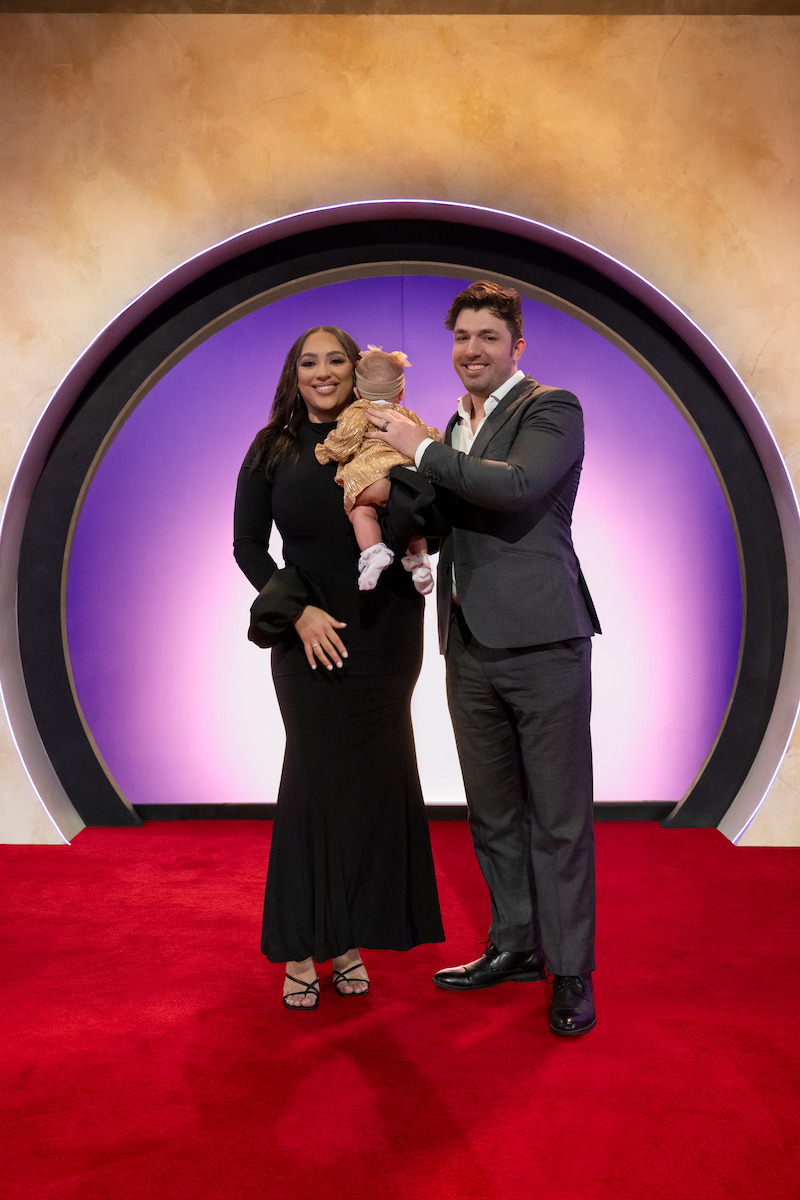 Bliss Poureetezadi Goytowski and Zack Goytowski holding their baby.