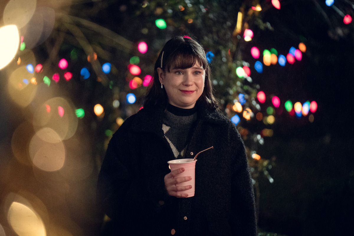 Jenny Walser smiles outside at night in Season 3 of ‘Heartstopper.’