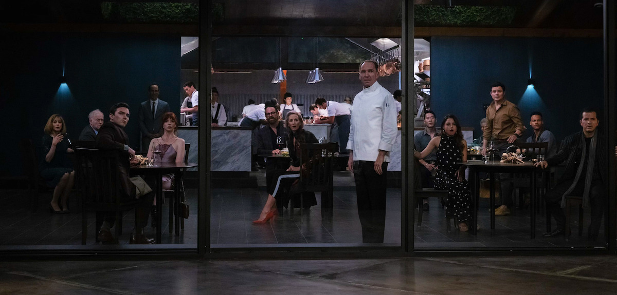 A group of people look out of floor-to-ceiling restaurant windows in ‘The Menu.’