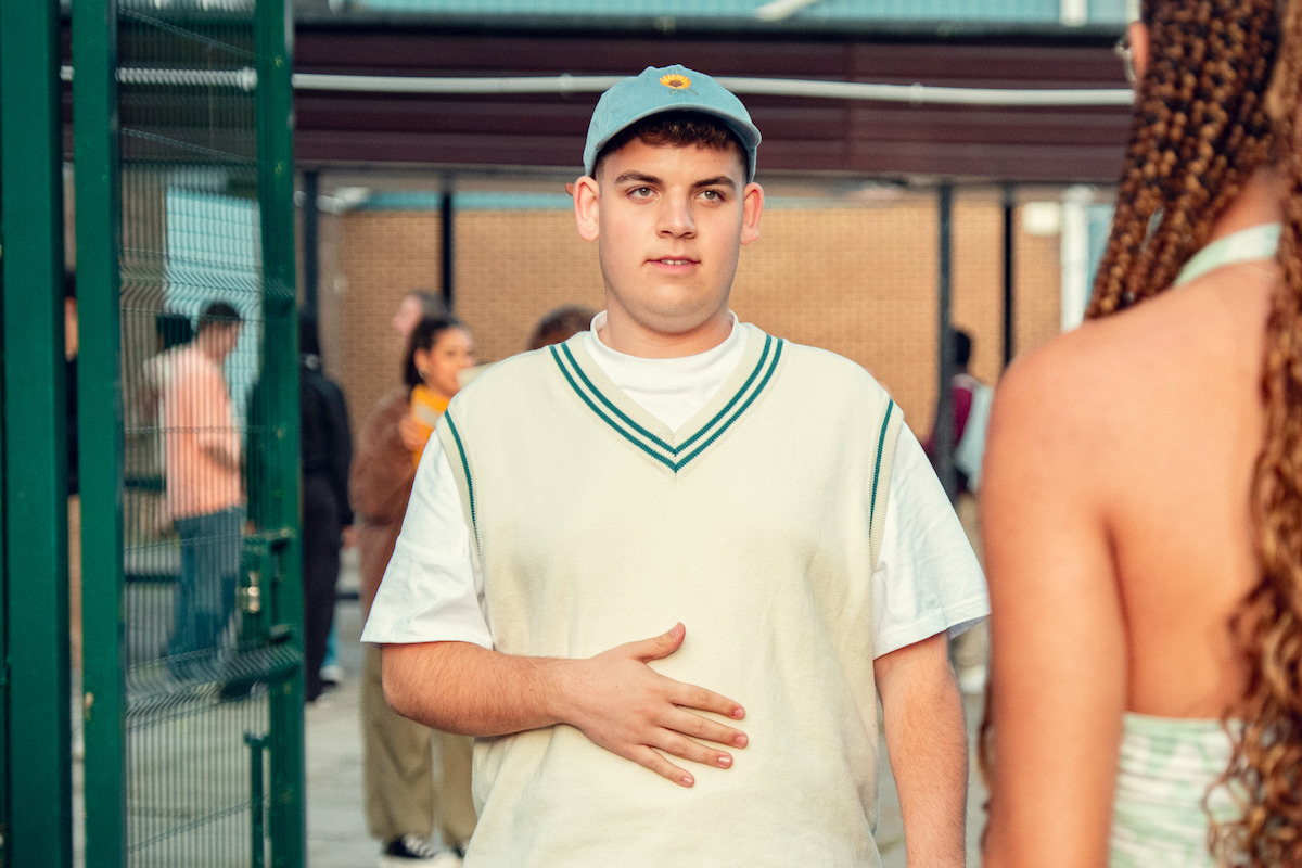 Tobie Donovan as Isaac wears a blue baseball cap in Season 3 of ‘Heartstopper.’