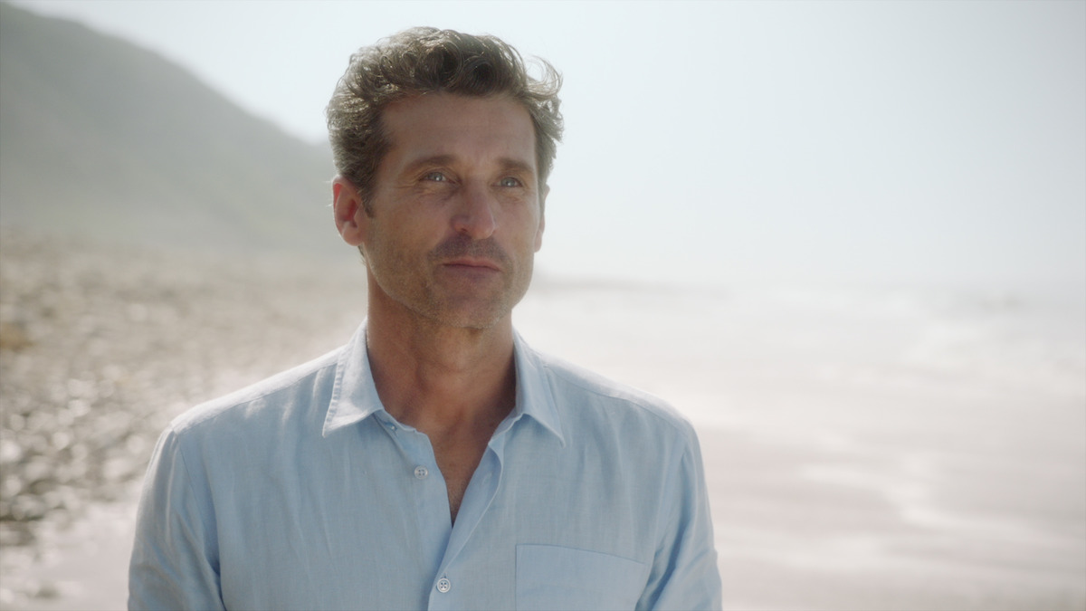 Patrick Dempsey standing on a beach . 
