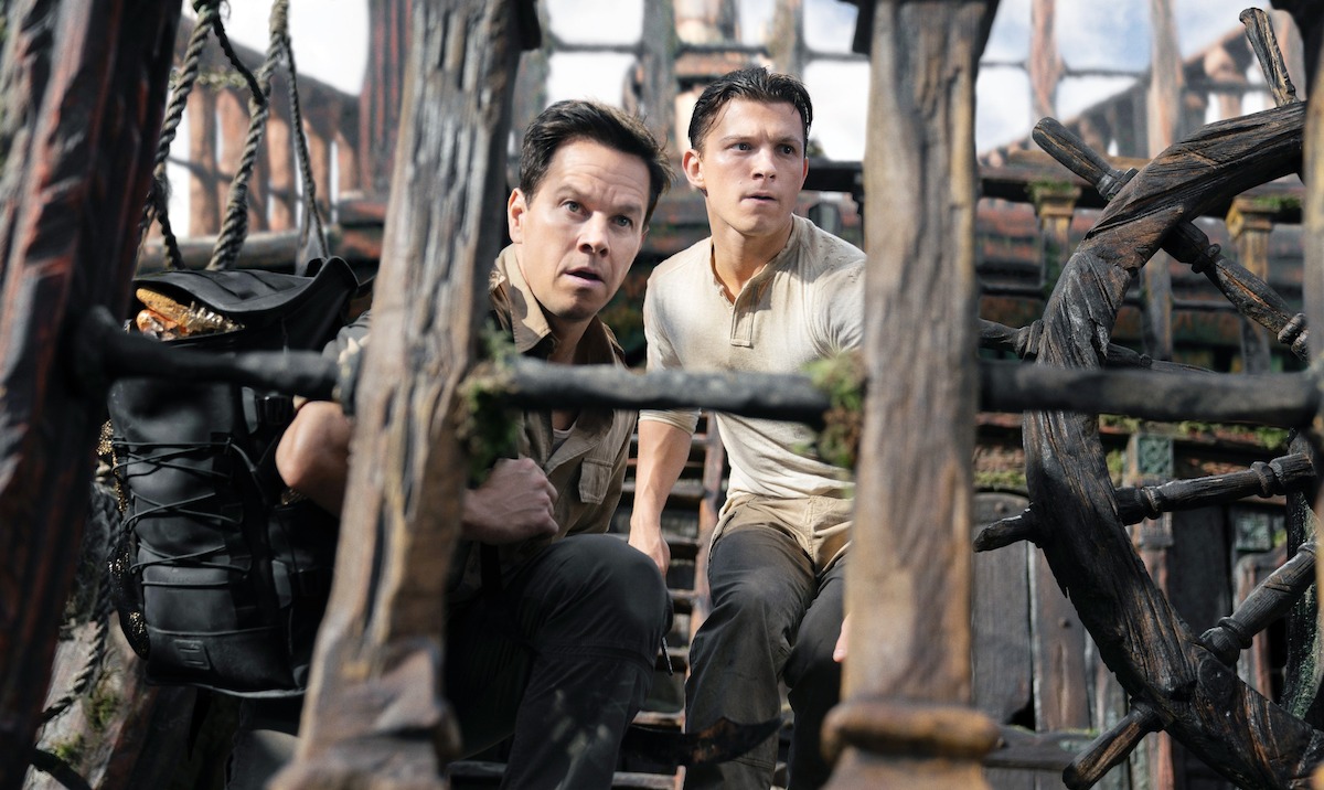 Two men stand on a wooden ship