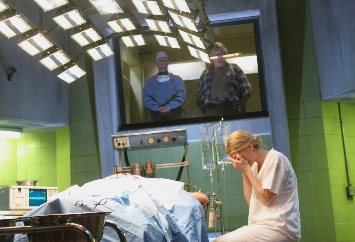 Elizabeth Mitchell covers her face with Michael Emerson on the operating table as Matthew Fox and M.c. Gainey look from an observation room.
