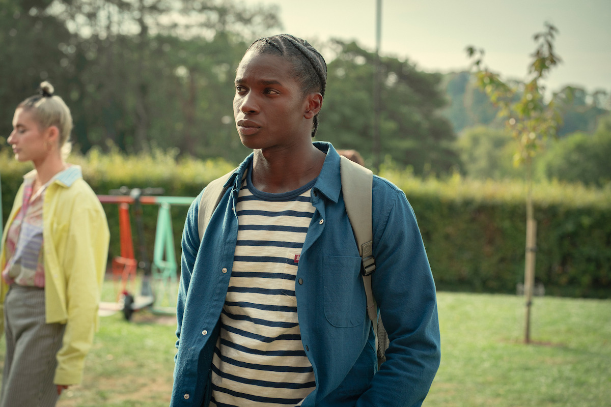 Kedar Williams-Stirling as Jackosn Marchetti stands outside at school in Season 4 of ‘Sex Education.’