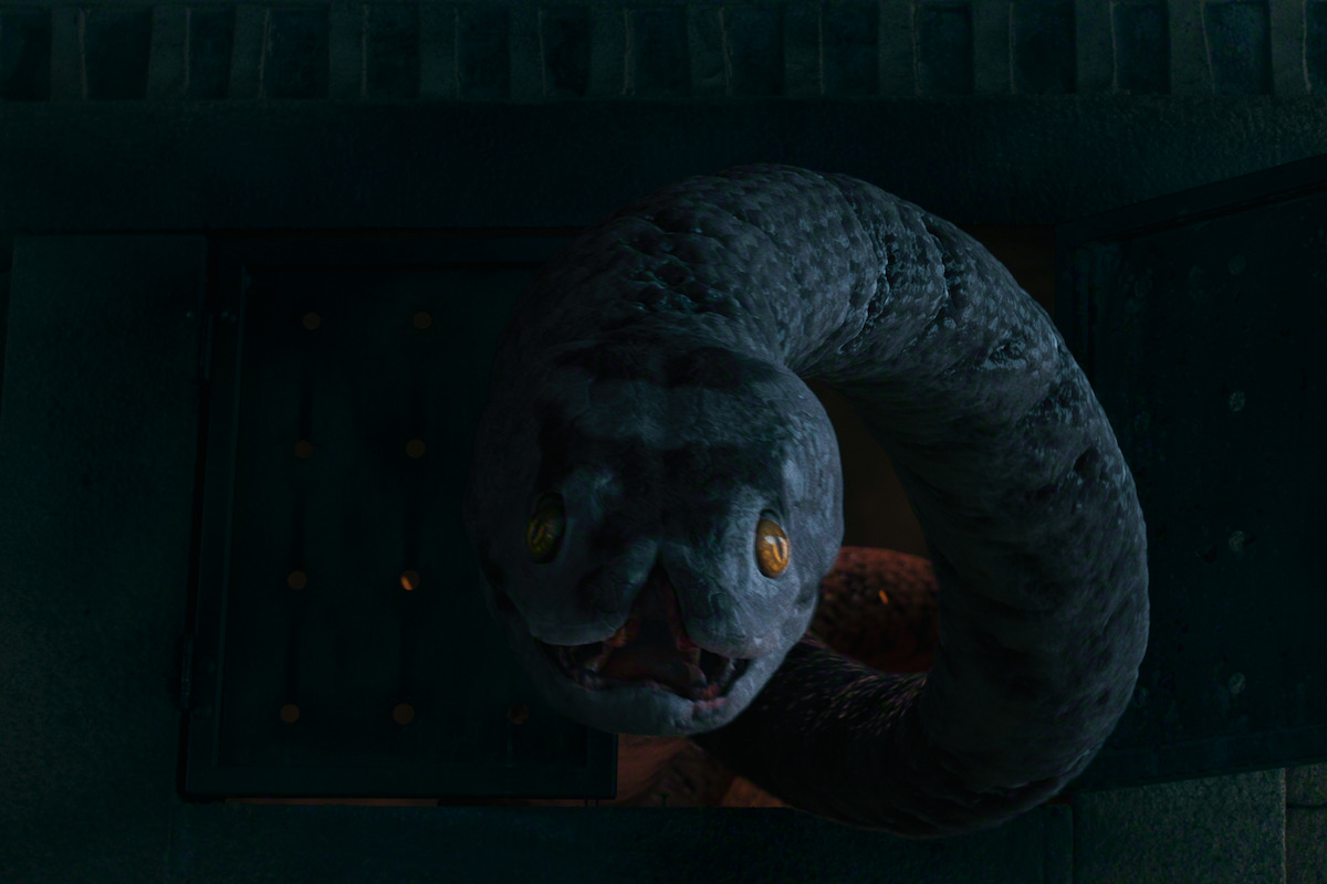 Large serpent with glowing yellow eyes emerging from a dark, stone-walled opening, creating a mysterious and ominous atmosphere in a dimly lit environment.