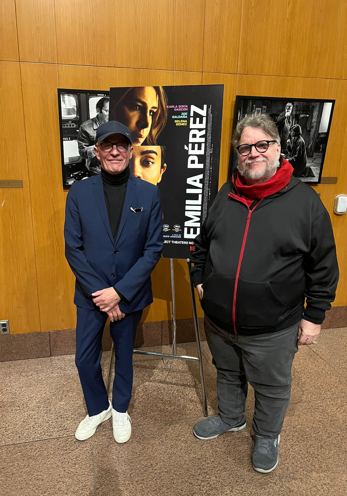 Jacques Audiard and Guillermo del Toro stand a few feet apart at an Emilia Pérez screening.