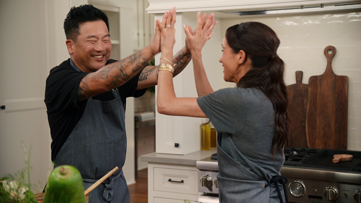 Roy Choi and Meghan high-fiving in the kitchen.