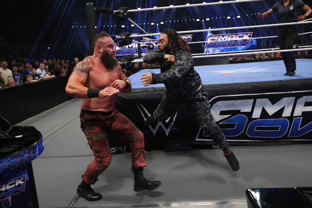 Braun Strowman fights Jacob Fatu outside of the ring.