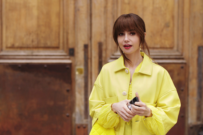 Lily Collins as Emily wears a bright yellow coat in Season 4 of 'Emily in Paris'