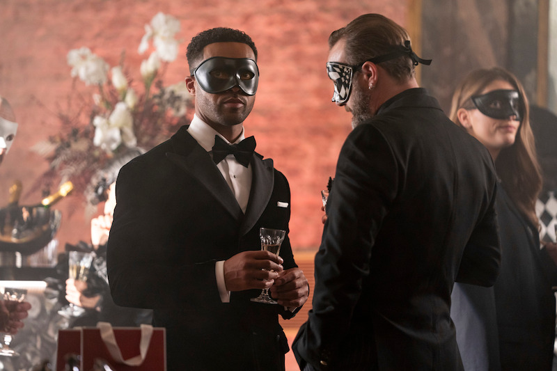 Lucien Laviscount as Alfie wears a masquerade mask at a party in Season 4 of 'Emily in Paris'