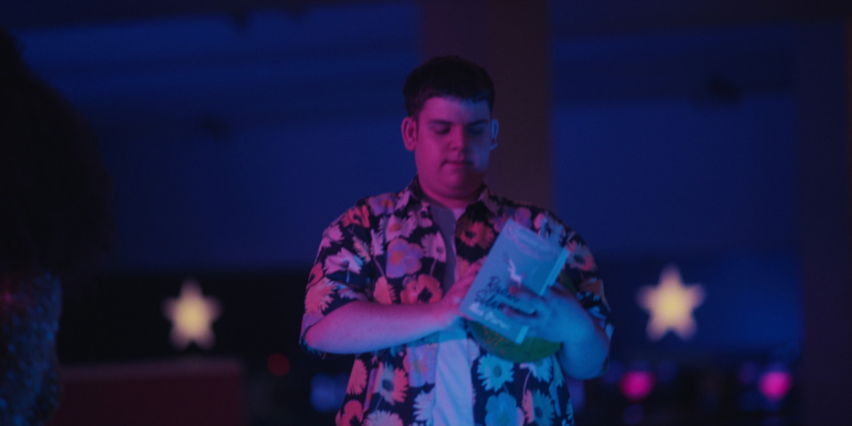 A scene from the Heartstopper TV show Season 1 Episode 5, 'Friend'. Isaac reads the Alice Oseman book 'Radio Silence', which features Nick, Charlie and Tori (the protagonist of 'Solitaire') and follows, beside Frances Janvier, the character Aled Last, whom Isaac replaces on the TV show.