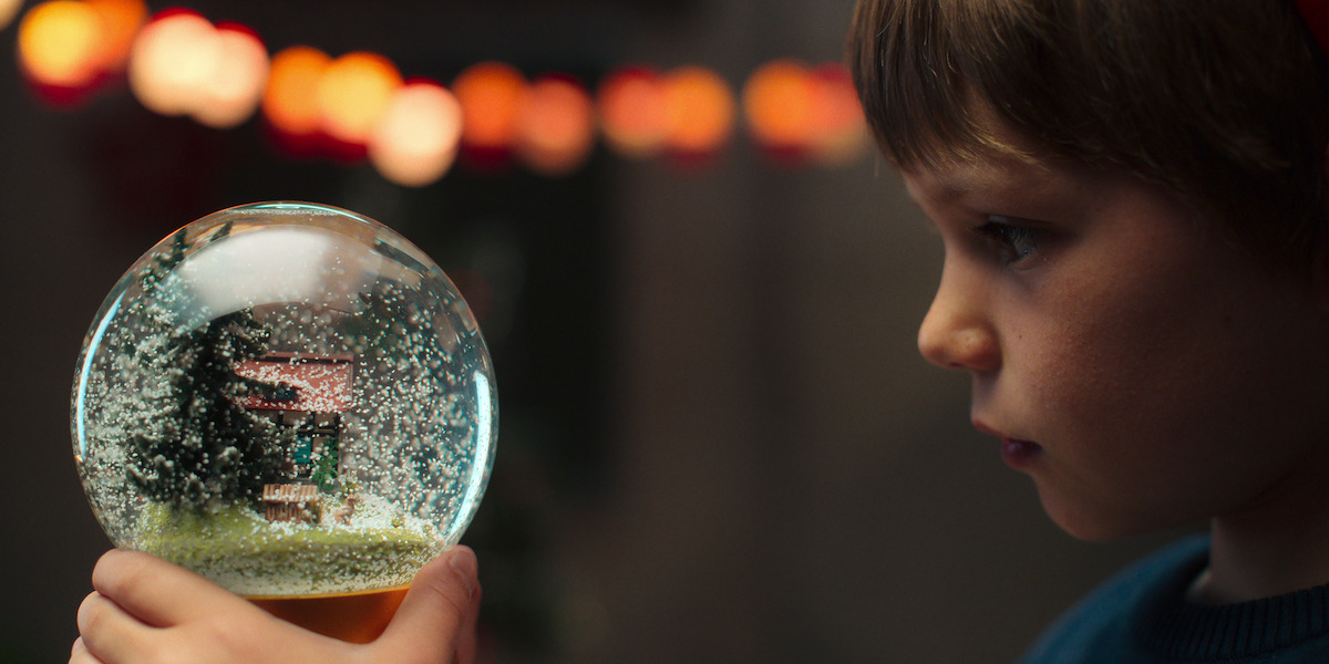 Sammy Schrein as Jonathan in Dear Child. A small boy looks into a snow globe.