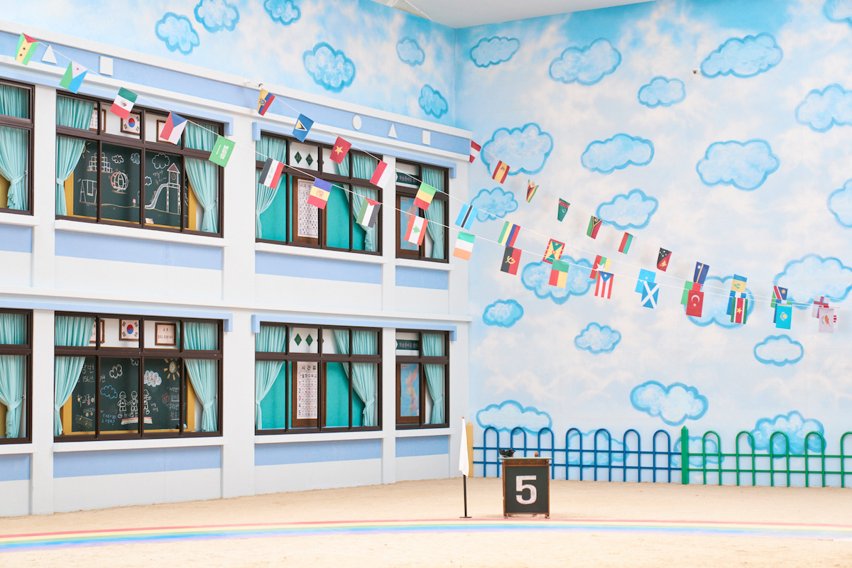 Relay games set featuring classroom windows and painted blue clouds in Season 2 of ‘Squid Game’