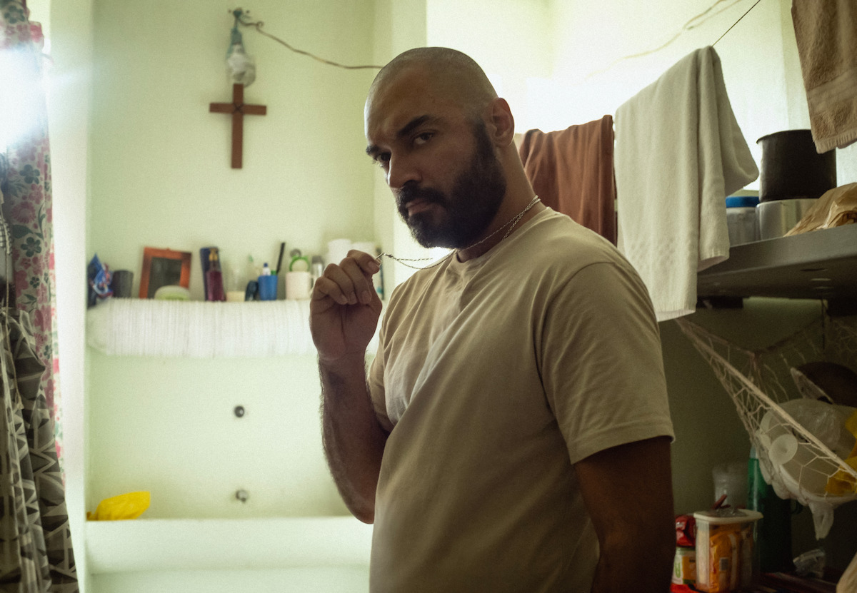Thomas Aquino posa na cela de uma prisão, em set da série ‘DNA do Crime’