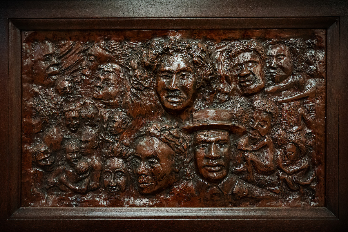 A detailed photograph of the piano from The Piano Lesson, featuring the faces of family ancestors carved into the wood.