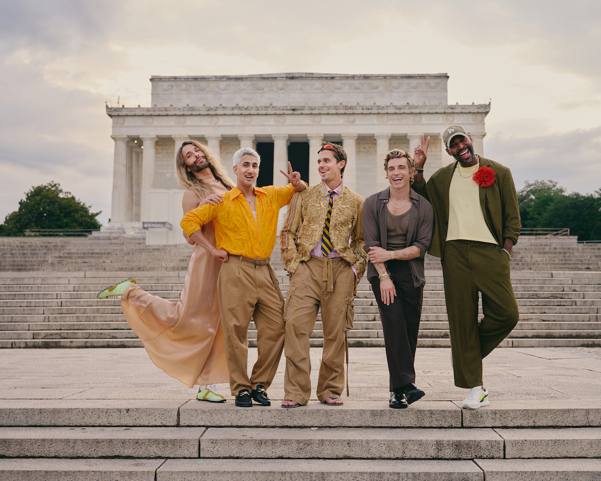Five people pose happily in colorful, fashionable clothing on the steps outside the Lincoln Memorial at sunset, smiling and making playful gestures, with the historic monument in the background.