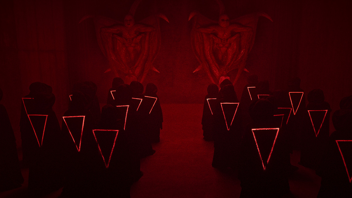 Hooded figures gather in front of stone statues in an image from the anthology series ‘Joko Anwar’s Nightmares and Daydreams.’