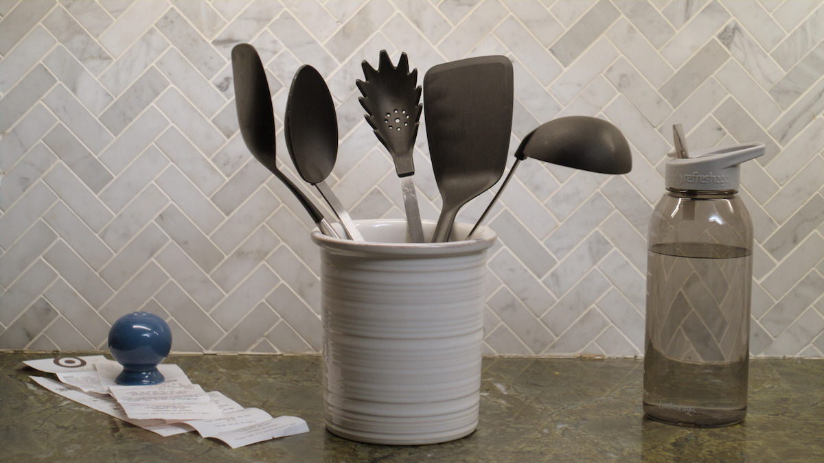 kitchen countertop with various plastic cooking utensils