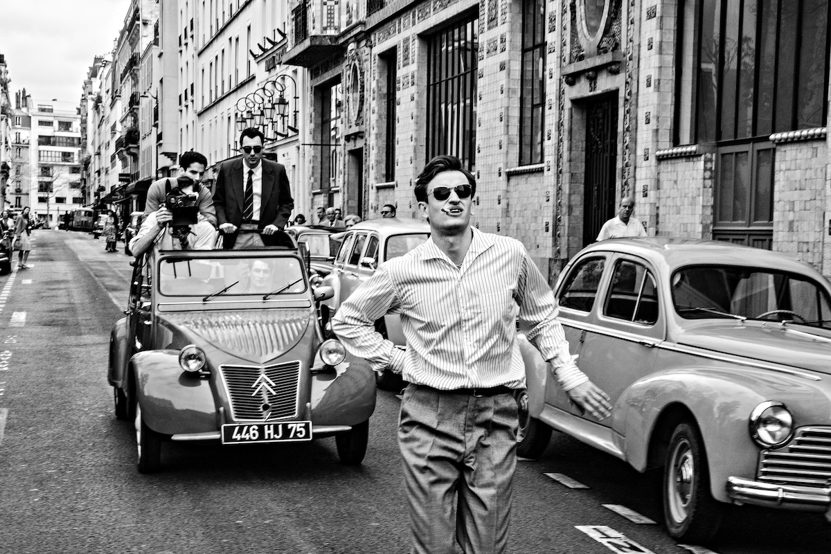 Jean Luc Godard (Guillaume Marbeck) and Jean-Paul Belmondo (Aubry Dullin) filming a scene from a car.