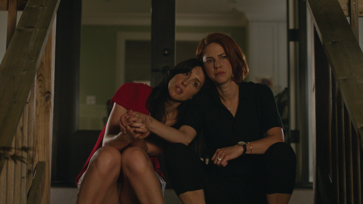 Catherine Reitman as Kate Foster and Dani Kind as Anne Carlson share a moment on a porch in 'Workin Moms.' 