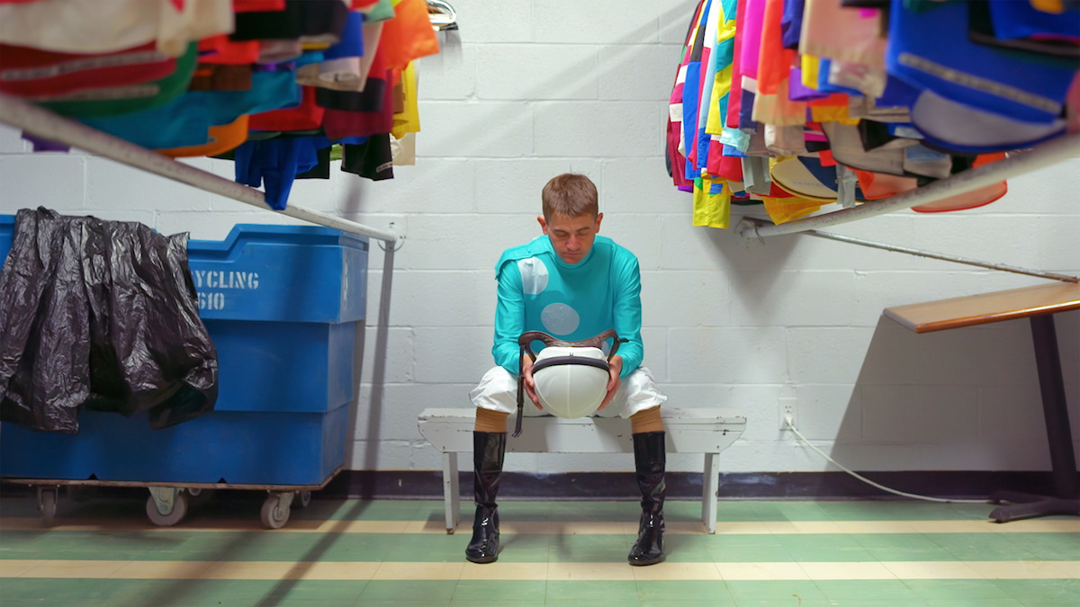 A jockey sitting on a bench