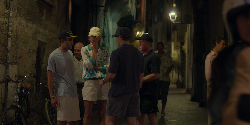 Blue and white jacket with gold embroidery, white shorts, baseball cap